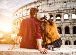 Na foto um casal em frente o Coliseu de Roma. É seguro reservar com a Get Your Guide? Leia o artigo para saber.