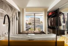 cama com vista para o Coliseu na suíte do Hotel Palazzo Manfredi Roma