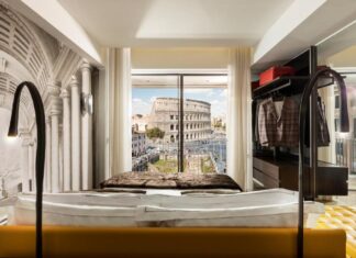 cama com vista para o Coliseu na suíte do Hotel Palazzo Manfredi Roma