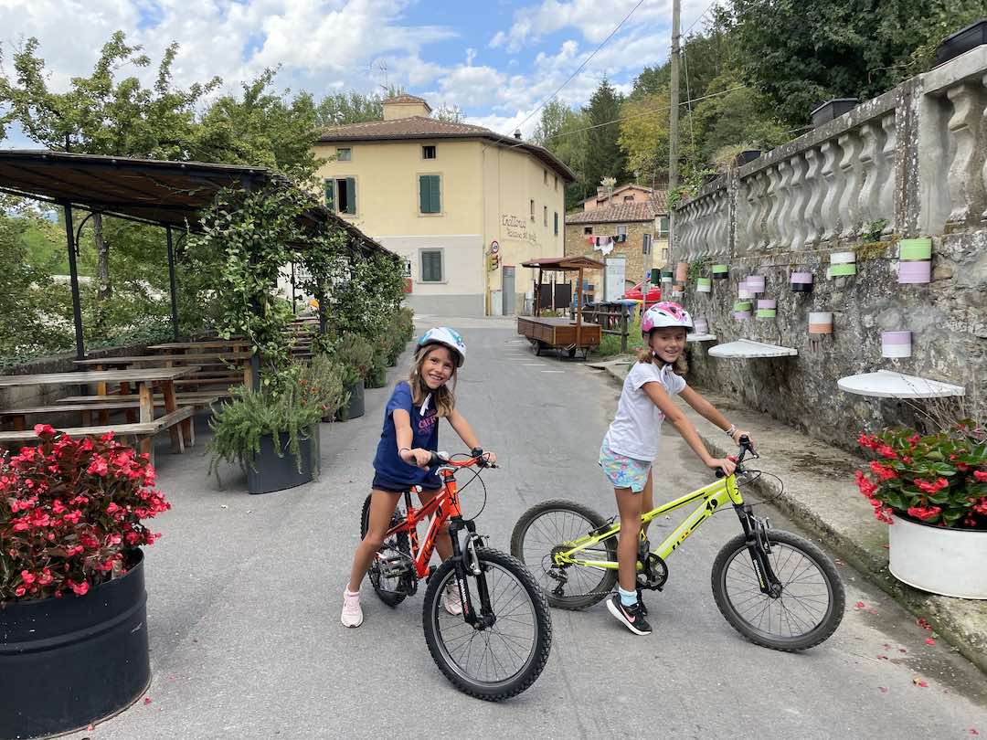 Olha aí minhas filhas Aurora e Gaia de bicicleta em frente a Casa del Prosciutto no dia 6 de setembro de 2022 - Nós adoramos a trilha que vai de Borgo San Lorenzo a Vicchio no Mugello