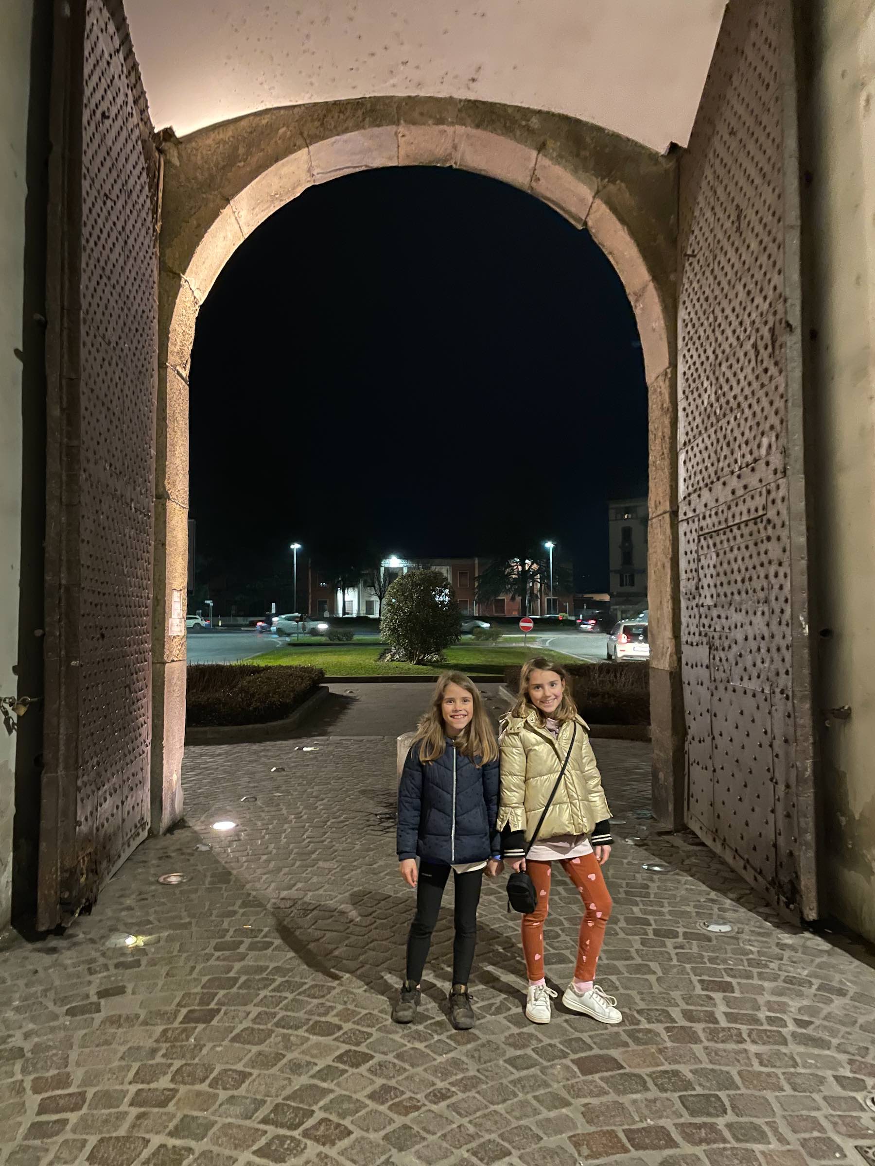minhas filhas Aurora e Gaia, pequenas diante da grandiosidade das portas no centro histórico de Lucca