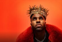 Jason Derulo olha para cima com expressão intensa, vestindo um casaco de pele vermelho e uma coroa dourada decorada com cristais, sobre fundo laranja vibrante. - Ingressos para Jason Derulo em Bolonha 2026