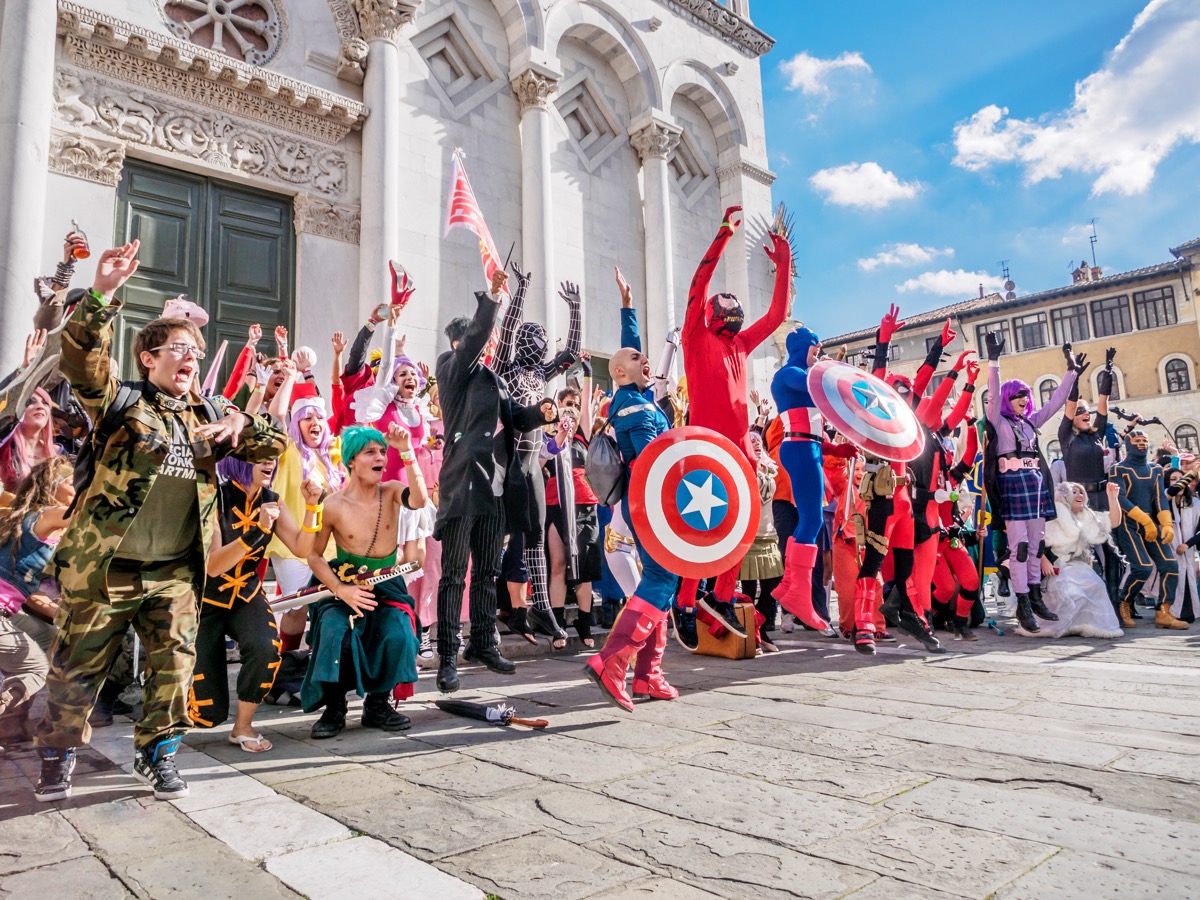 Grupo de cosplayers posa em frente a uma igreja histórica durante o Lucca Comics & Games na Toscana.