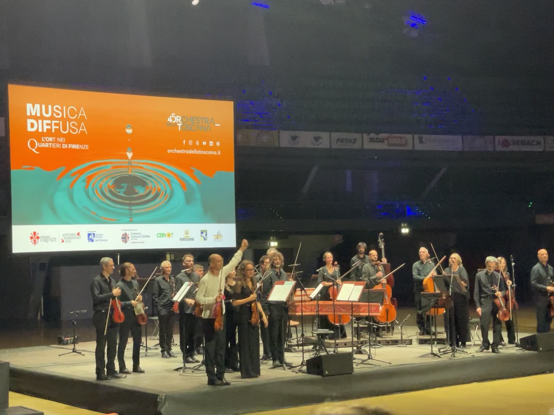 Giacomo Bianchi e a Orchestra della Toscana agradecem os aplausos do público no Nelson Mandela Forum, em Florença durante o Musica Diffusa