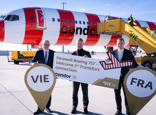 Condor se despede do Boeing 757-300 com uma festa nas alturas 1 Executivos da Condor e do Aeroporto de Viena seguram uma placa com os dizeres “Farewell Boeing 757 – Welcome 3rd Frankfurt connection” em frente a uma aeronave da Condor com pintura vermelha e branca.