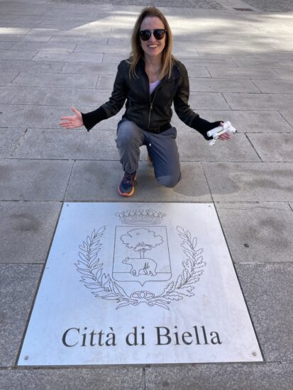 Tirando fotinho com placa no chão da cidade de Biella