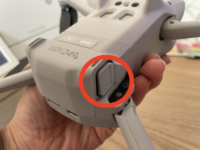 Este é um dos botões laterais que você deve apertar para extrair a bateria do DJI Mini 3