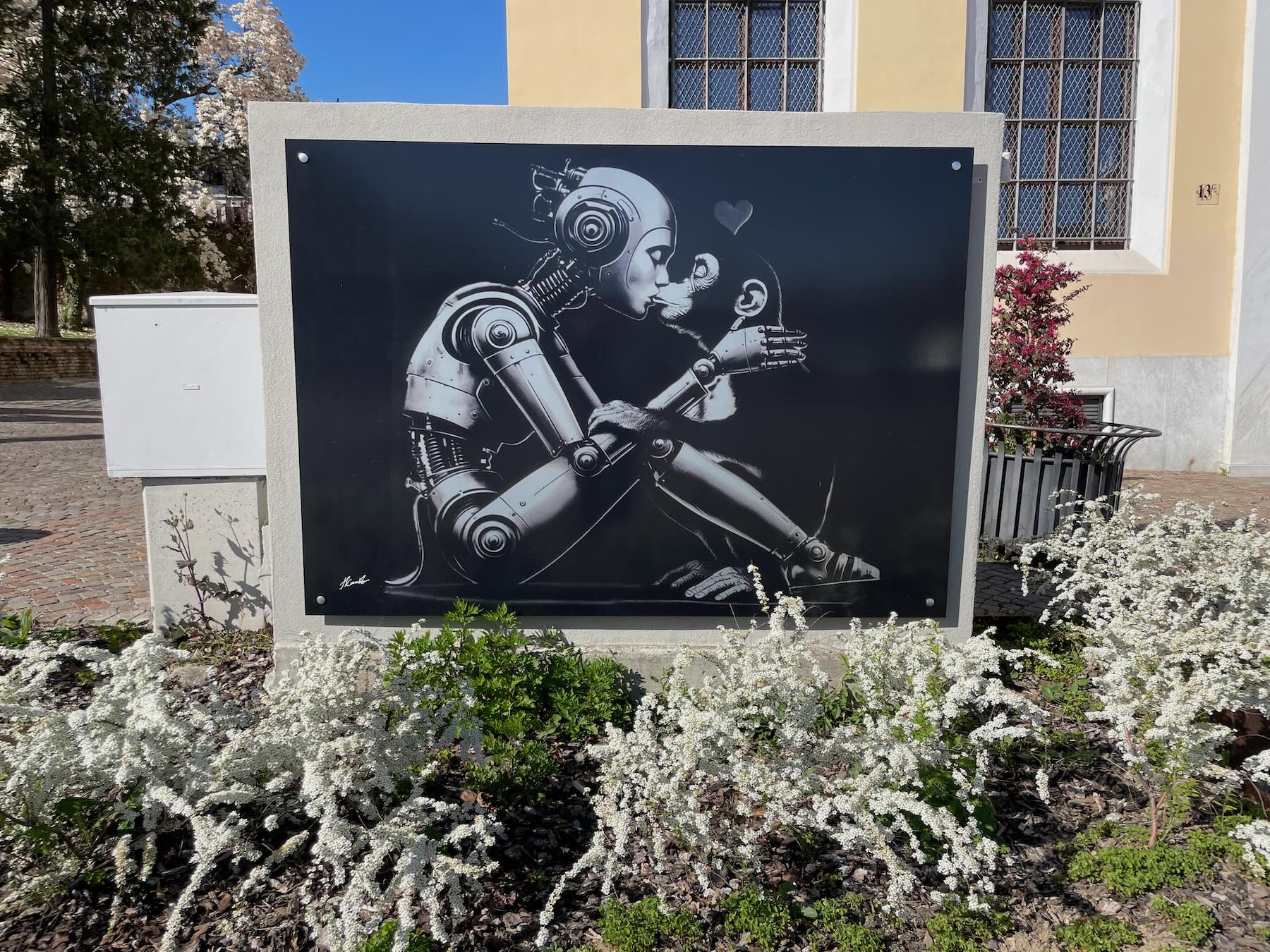 O amor entre um robô e um macaco em um grafite nos arredores do funicular em Biella Piano