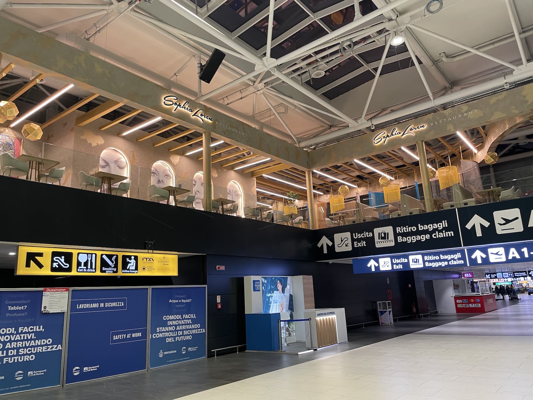 Área de desembarque do Aeroporto de Roma Fiumicino com placas de saída, retirada de bagagem e conexões