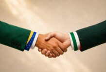 Aperto de mãos com mangas nas cores das bandeiras do Brasil e da Itália, simbolizando a parceria comercial entre os dois países