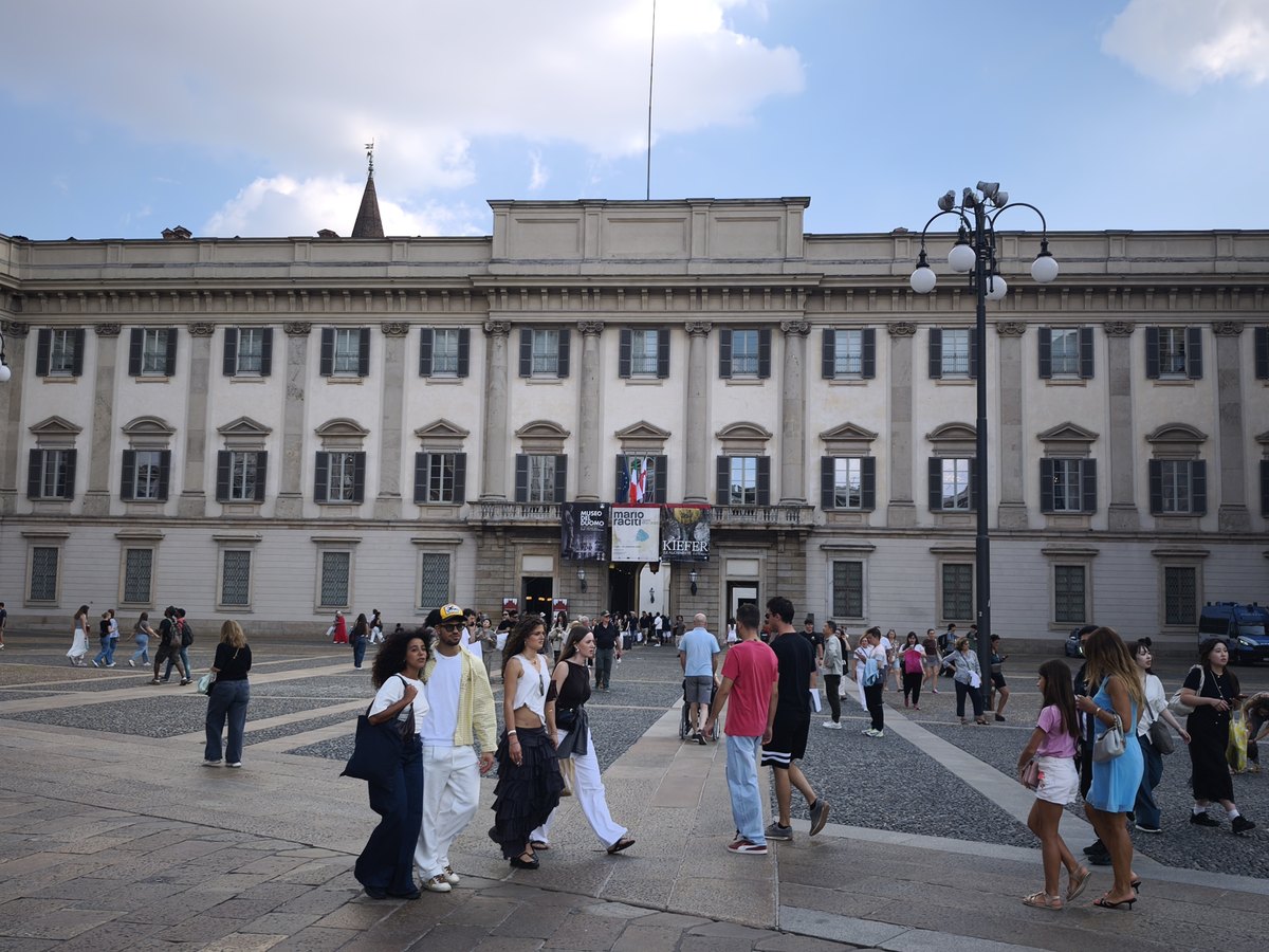 Dalí e la Moda em Milão: ingressos, horários e o que ver 1 Fachada do Palazzo Reale na Piazza del Duomo, em Milão, com movimento de pedestres e cartazes de exposições