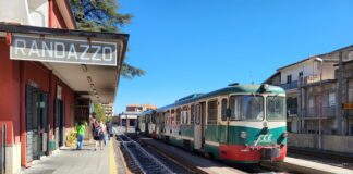 Trem verde e vermelho da Ferrovia Circumetnea parado na estação de Randazzo, na Sicília